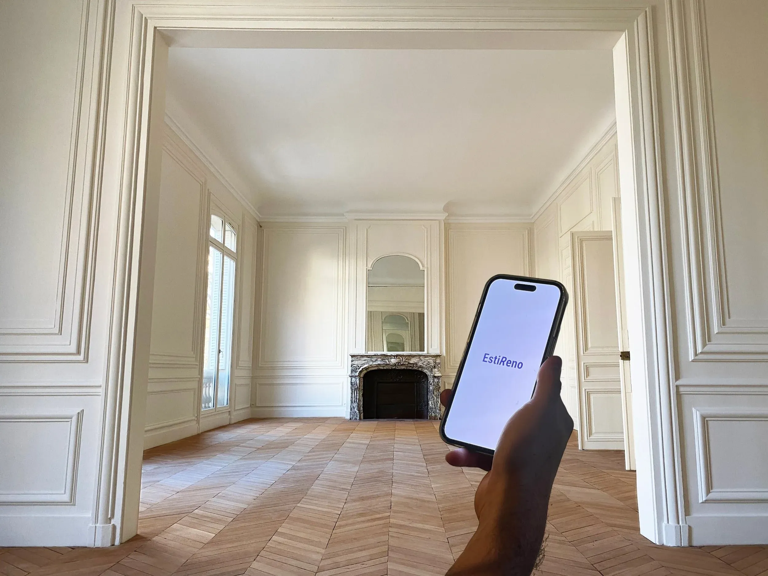 Un appartement haussmannien à rénover, avec l'application EstiReno ouverte sur un téléphone